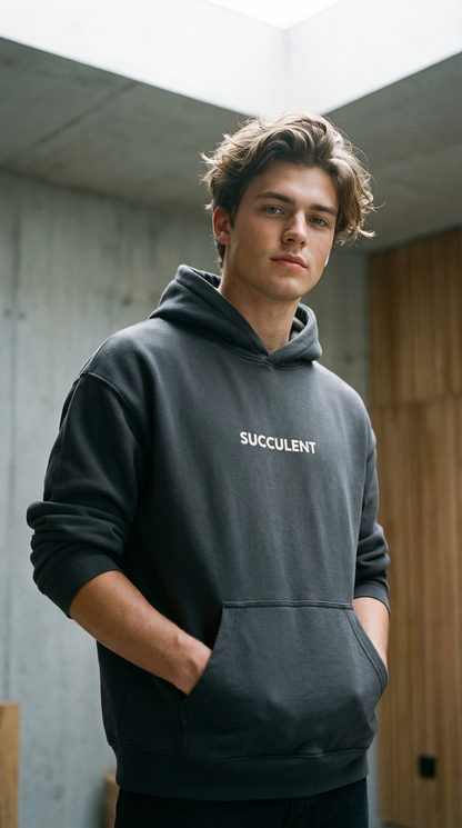 Person wearing a dark hoodie with 'SUCCELENT' text, standing indoors.